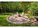 Outdoor fire pit area with stone border and seating, perfect for entertaining at 4405 New Brighton Dr, Apex, NC 27539