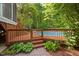 Backyard pool area surrounded by a wooden deck and landscaping at 4405 New Brighton Dr, Apex, NC 27539