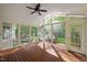 Enclosed sunroom with wood floors, ceiling fan, and glass windows at 4405 New Brighton Dr, Apex, NC 27539