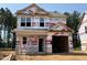 Under-construction two-story home featuring a modern design, visible framing, and protective housewrap at 49 Goldenrod Loop, Clayton, NC 27520