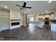 Spacious living room with a modern fireplace, built-in shelves, hardwood floors, and a kitchen in the back at 49 Goldenrod Loop, Clayton, NC 27520