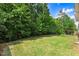 Lush green backyard surrounded by mature trees and greenery offers a private retreat at 494 Mulberry Banks Dr, Clayton, NC 27527