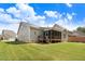 Spacious backyard featuring a covered porch, lush green lawn, and mature trees at 494 Mulberry Banks Dr, Clayton, NC 27527