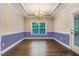 Well-lit dining room with wood floors, chair railing, large window, and elegant chandelier at 494 Mulberry Banks Dr, Clayton, NC 27527