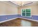 Well-lit dining room with hardwood floors, large window, custom chair railing, and modern chandelier at 494 Mulberry Banks Dr, Clayton, NC 27527