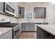 Gray cabinets, granite counters, subway tile backsplash, and stainless steel appliances in this modern kitchen at 494 Mulberry Banks Dr, Clayton, NC 27527