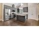 Modern kitchen with stainless steel appliances, gray cabinets, granite countertops, and wood floors at 494 Mulberry Banks Dr, Clayton, NC 27527