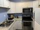 Efficient kitchen with stainless steel appliances, granite countertops, and white cabinets at 500 Umstead # 208D, Chapel Hill, NC 27516
