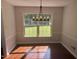 Sunlit dining room with dark hardwood floors, and an elegant light fixture for gatherings at 5026 Gatewood Drive Dr, Durham, NC 27712