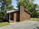 Brick exterior with a small porch and gravel driveway at 5026 Gatewood Drive Dr, Durham, NC 27712