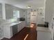 Well-lit kitchen with white cabinetry, stainless steel appliances, and a stylish wallpaper accent at 5026 Gatewood Drive Dr, Durham, NC 27712