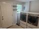 Convenient laundry room with washer, dryer, shelving, and door to the exterior at 5026 Gatewood Drive Dr, Durham, NC 27712