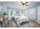Comfortable bedroom featuring light blue walls, wood flooring, a ceiling fan and two windows with natural light at 53 Forest Oaks Dr, Durham, NC 27705