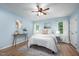 Bright blue bedroom with white furniture, light fixtures, a window, and wood floors at 53 Forest Oaks Dr, Durham, NC 27705