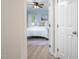 View to a light blue bedroom with light fixtures, and a window with natural light at 53 Forest Oaks Dr, Durham, NC 27705