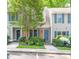 Charming townhome exterior featuring gray siding, brick accents, blue shutters, and mature landscaping at 53 Forest Oaks Dr, Durham, NC 27705