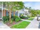 Exterior view of townhomes showcasing well-maintained landscaping, brick accents, and blue shutters at 53 Forest Oaks Dr, Durham, NC 27705