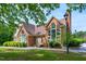 Charming brick home featuring a prominent chimney, arched windows, and a well-manicured front yard at 53 Forest Oaks Dr, Durham, NC 27705