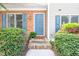 Inviting front door with blue shutters, a charming brick facade, and lush landscaping at 53 Forest Oaks Dr, Durham, NC 27705