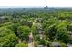 This high-angle shot captures a peaceful residential neighborhood with lush greenery and distant city skyline at 5505 Knollwood Rd, Raleigh, NC 27609