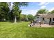Relaxing backyard featuring a wooden deck with outdoor seating, lush green lawn, and mature trees at 5505 Knollwood Rd, Raleigh, NC 27609
