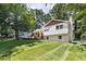 Large backyard with lush green grass and mature trees offers serene privacy at 5505 Knollwood Rd, Raleigh, NC 27609