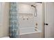 A clean and stylish bathroom with a white tub and shower featuring a blue patterned shower curtain at 5505 Knollwood Rd, Raleigh, NC 27609