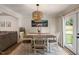 Dining room with tan walls, wood table, modern chandelier, and view of an outdoor area at 5505 Knollwood Rd, Raleigh, NC 27609