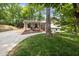 Beautifully landscaped home with a covered porch, complemented by mature trees and lush green grass at 5505 Knollwood Rd, Raleigh, NC 27609