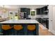 Stylish kitchen featuring dark green cabinetry, stainless steel appliances, and an island with seating at 5505 Knollwood Rd, Raleigh, NC 27609