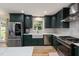 Modern kitchen featuring hunter-green cabinets, stainless steel appliances, and white countertop at 5505 Knollwood Rd, Raleigh, NC 27609