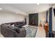 Spacious living room with a comfy gray sectional, stylish fireplace, and warm lighting, inviting relaxation and enjoyment at 5505 Knollwood Rd, Raleigh, NC 27609