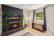 Cozy living area featuring a fireplace with plants, warm lighting, and a wooden table for a welcoming atmosphere at 5505 Knollwood Rd, Raleigh, NC 27609