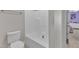 Bathroom featuring a toilet and tub-shower combo with white walls and tile flooring at 615 Prides Crsg Xing, Rolesville, NC 27571