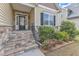 Welcoming front entrance with stone steps, flowering shrubs, and a stylish glass-paneled door at 615 Prides Crsg Xing, Rolesville, NC 27571