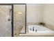 Bathroom featuring a jetted tub, glass enclosed shower and tile surround at 629 Houndsditch Cir, Wake Forest, NC 27587
