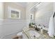 Elegant powder room with granite countertop, stylish mirror, and tasteful wall paneling at 629 Houndsditch Cir, Wake Forest, NC 27587