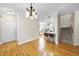 Dining room featuring wood floors and chandelier lighting next to the stairway and kitchen at 629 Houndsditch Cir, Wake Forest, NC 27587