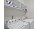 Laundry room featuring modern white front load washer and dryer and shelving at 629 Houndsditch Cir, Wake Forest, NC 27587