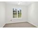 Bedroom featuring neutral carpet, white walls, and a window offering view of the outdoors at 6539 Clarksdale Ln, Durham, NC 27713