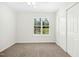 Bedroom with neutral carpet, large window with blinds, white walls and closet with sliding doors at 6539 Clarksdale Ln, Durham, NC 27713