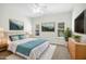 Bright bedroom features a queen bed, neutral walls, two windows with natural light, and decorative paintings at 6539 Clarksdale Ln, Durham, NC 27713