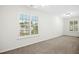 Carpeted bedroom with two large windows that let in ample natural light and provide pleasant neighborhood views at 6539 Clarksdale Ln, Durham, NC 27713