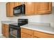 Kitchen detail with wooden cabinets, countertops, and black appliances at 6539 Clarksdale Ln, Durham, NC 27713