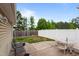 Relaxing backyard with a concrete patio, surrounded by lush greenery and a white fence at 7028 Pebble Brook Way, Rocky Mount, NC 27804