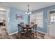 Cozy dining area with a round table, four chairs, and a modern chandelier at 7028 Pebble Brook Way, Rocky Mount, NC 27804
