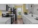 Efficient kitchen featuring white cabinets, modern appliances, and a bright window at 7028 Pebble Brook Way, Rocky Mount, NC 27804