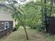 View of a backyard with grass, wooden shed, and a variety of trees and bushes at 7412 Barberry Ct, Raleigh, NC 27615