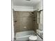 Tiled tub and shower combination with built-in shelving and sliding door cabinet at 7412 Barberry Ct, Raleigh, NC 27615