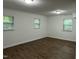 Spacious bedroom with wood-look floors, fresh paint, and ample natural light from three windows at 7412 Barberry Ct, Raleigh, NC 27615
